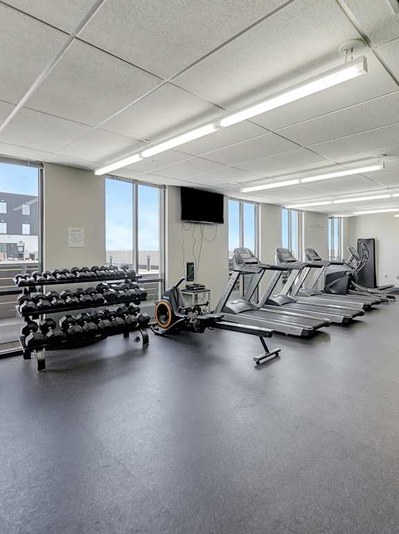A gym with a variety of equipment including treadmills, weights, and exercise bikes at Parkhaus Apartments,Nebraska