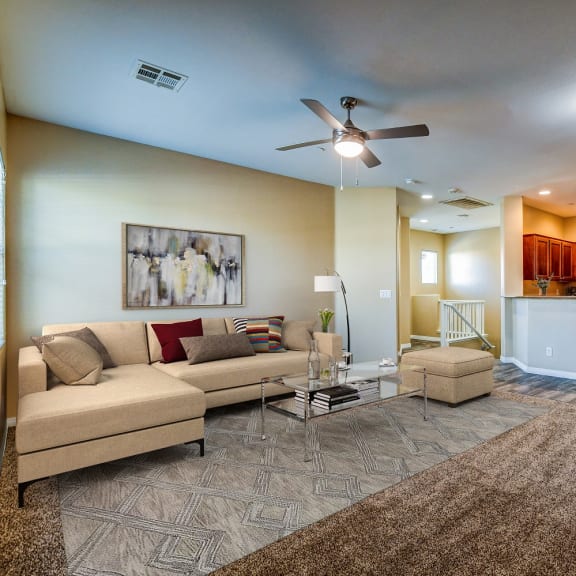 a living room with a couch and a ceiling fan