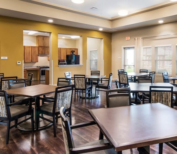 Community room with tables, chairs, and kitchenette, Wheatley Park Senior Living