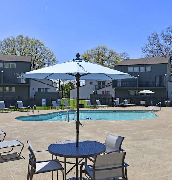 our apartments have a large pool and patio with chairs and tables