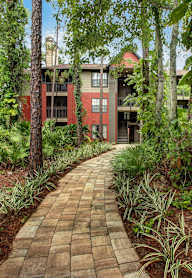 A brick pathway leads through a lush green garden.