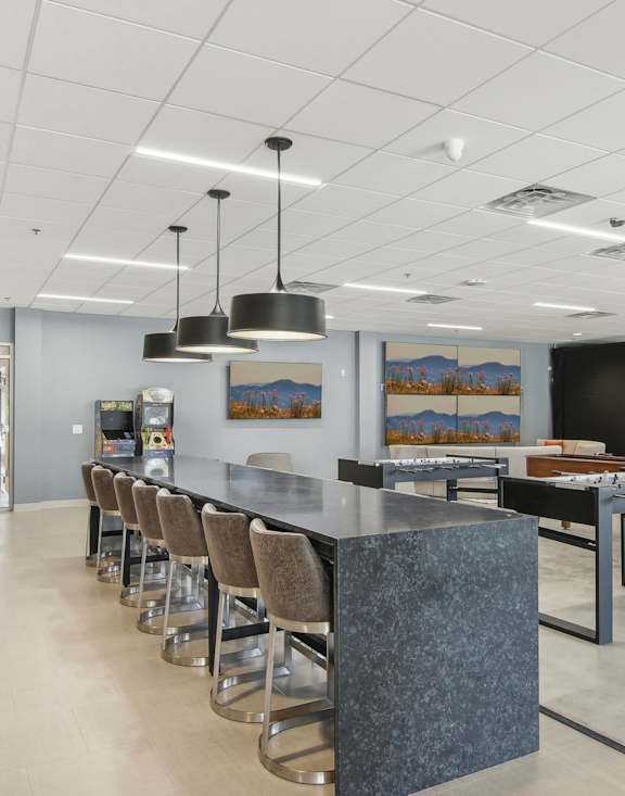 the lobby of a restaurant with a long counter and chairs