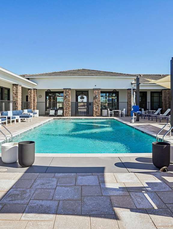 A large swimming pool surrounded by lounge chairs and umbrellas.at The Ranches at Gunsmoke, Maricopa, AZ 85138