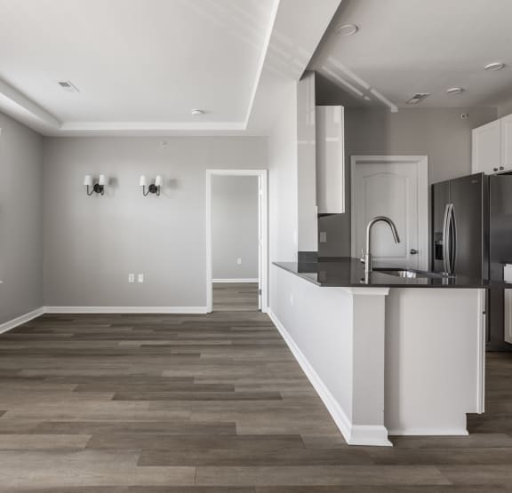 a vacant open concept living and kitchen room with plank flooring and luxury finishes at Alexandria of Carmel Apartments, Indiana