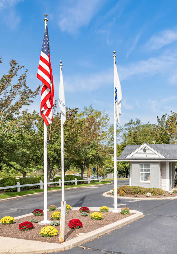 Road with two flags and fence at Four Winds Apartments, Fall River, 02720