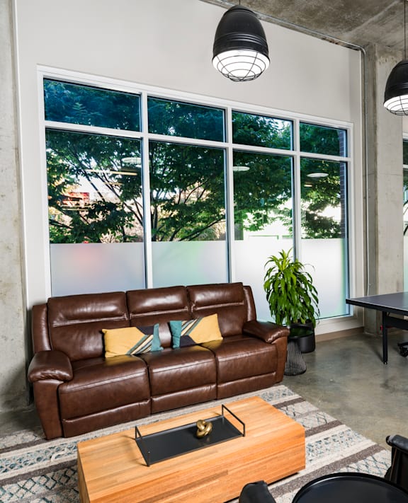 A living room with a brown leather couch and a coffee table.