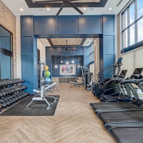 a large fitness room with a row of treadmills and other exercise equipment at Muse Carmel in Carmel