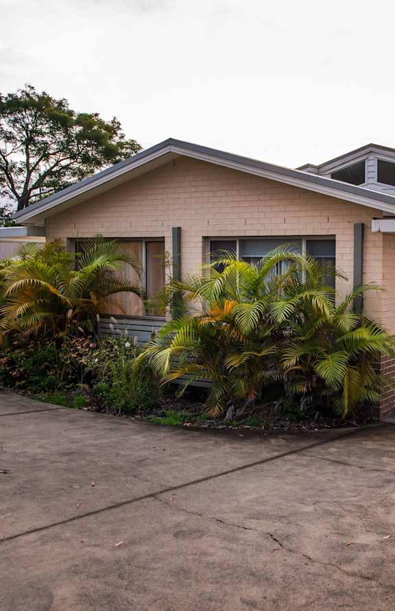 A house with a driveway and a car parked in front.