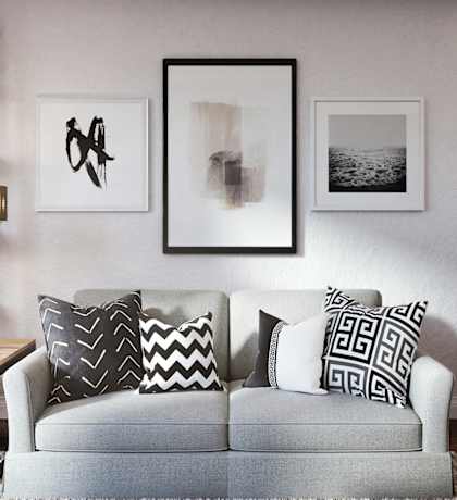 a living room with a couch and a rug and pictures on the wall