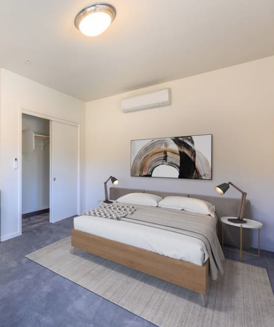 a bedroom with a bed and a washing machine in a room