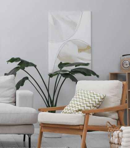 A living room with a white couch, a wooden chair, a wooden table, and a potted plant.