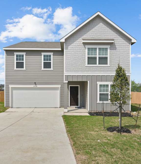 a house with a gray siding and a white garage door