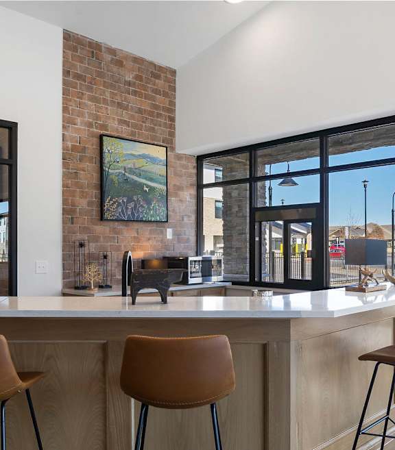 A kitchen with a bar area and chairs.