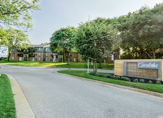 A street view of a residential area with a sign that reads