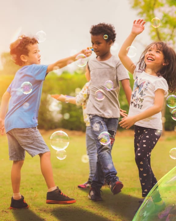 Kids Smiling while Playing with Bubbles