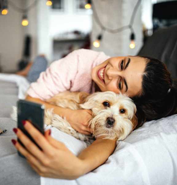A woman is lying on a bed with a dog at Stillwater Lakes Apartments, Kissimmee, 34744