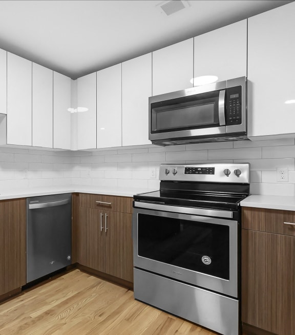 a kitchen with white cabinets and stainless steel appliances at 1188 Lofts in Bridgeport, CT, 06604