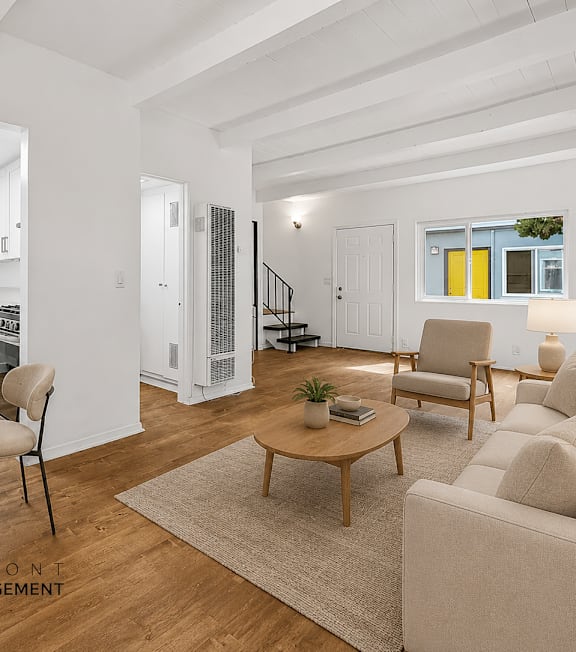 A well-lit, modern kitchen and living room with a dining area.