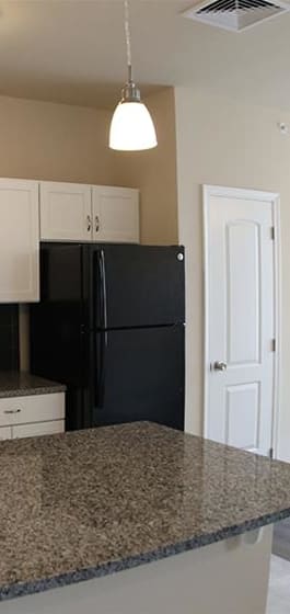 a kitchen with white cabinets and a black stove and refrigerator