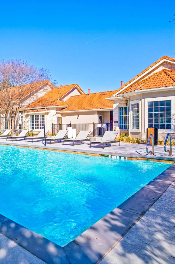 a swimming pool with lounges around it at The Olivine in North Austin, Texas