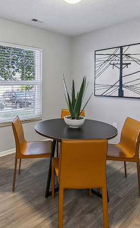 A dining room with a round table and chairs.