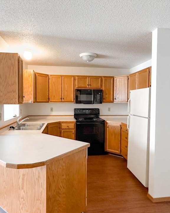 A kitchen with wooden cabinets and a white countertop.