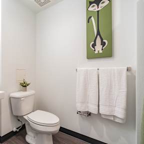 A bathroom with a toilet, sink, and towels.