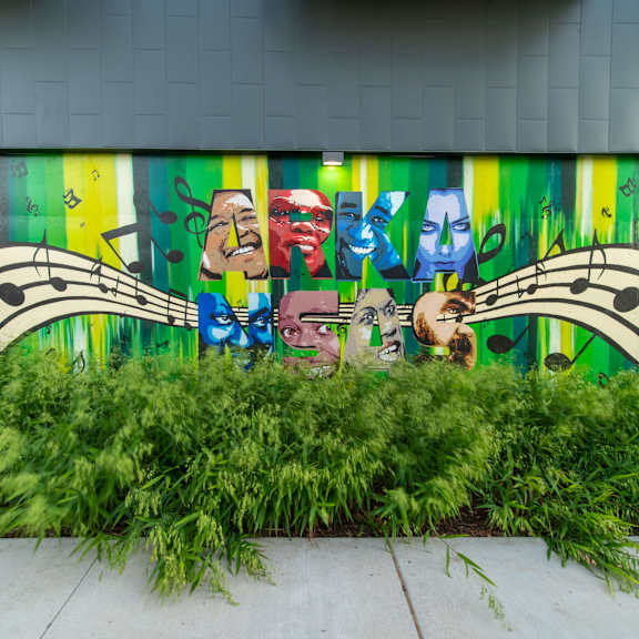 A mural of a man with a guitar is painted on a wall.