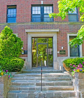 the front of a brick building with steps and a glass door