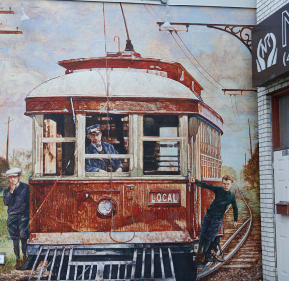 a mural of a streetcar on the side of a building