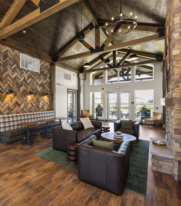 A living room with a stone fireplace and a large window.