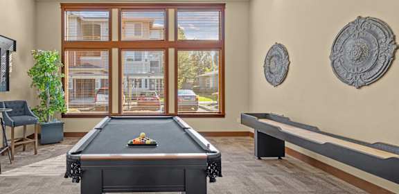 a game room with a pool table and a large window