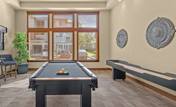 a game room with a pool table and a large window