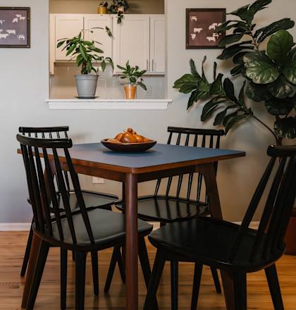 a dining room with a table and chairs and a refrigerator