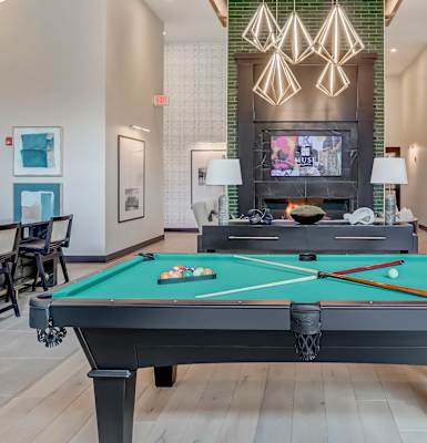a billiards room with a pool table and chairs