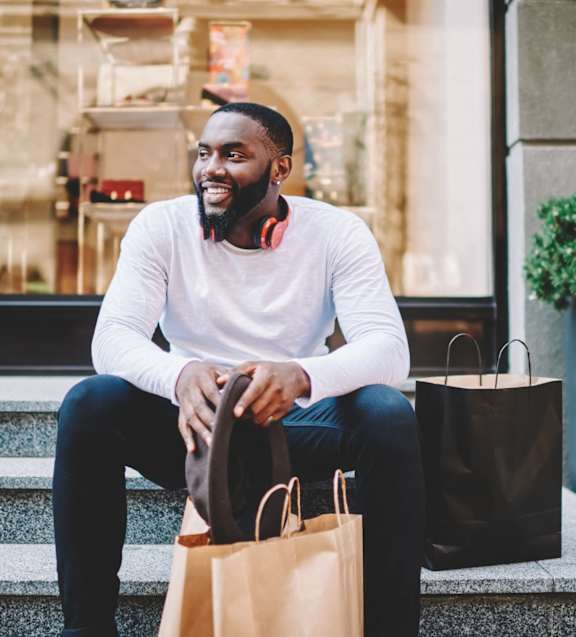 A man seating in front of a shop at Chelsea Apartments, Missouri