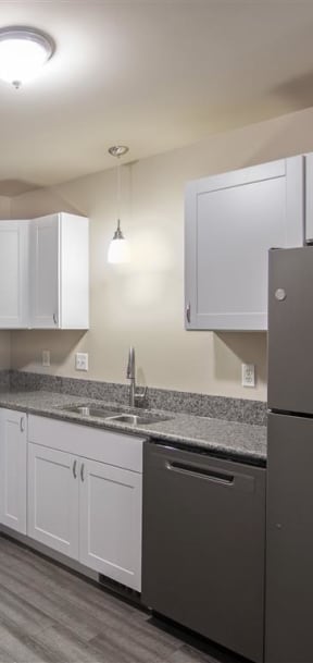 a kitchen with white cabinets and a black stove and refrigerator