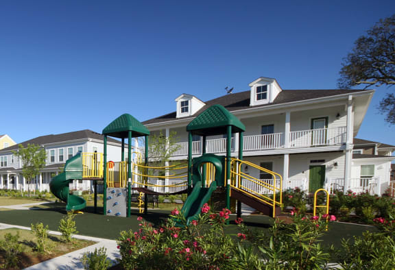 a playground in a park in front of apartments
