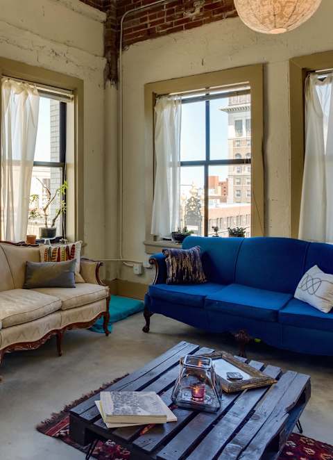 A living room with a blue couch and a wooden coffee table.