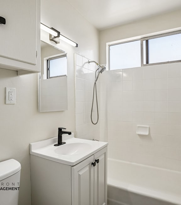 A white bathroom with a toilet, sink, and bathtub.