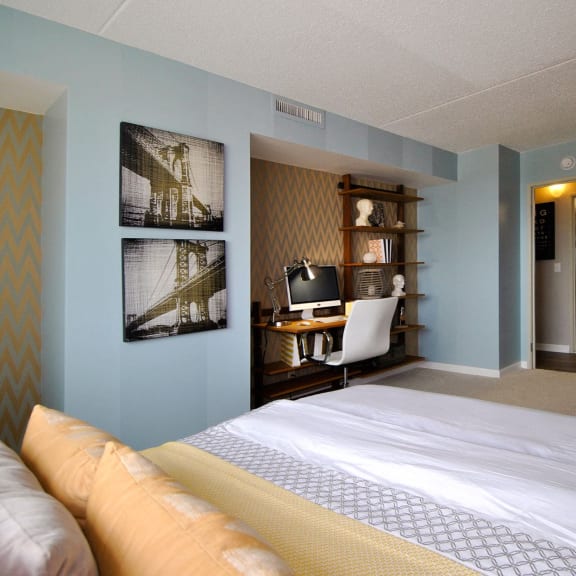 a bedroom with a bed and a desk in a hotel room