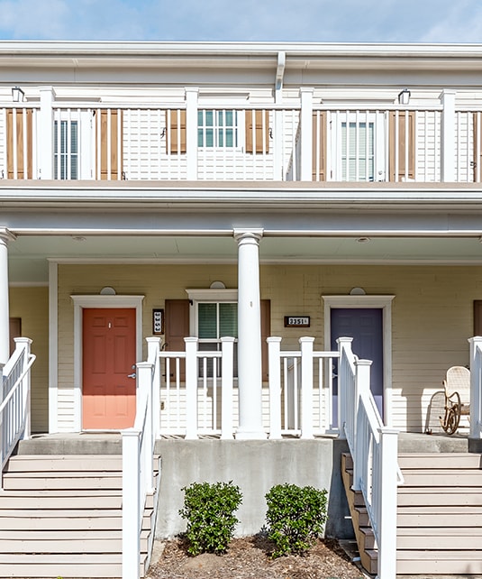 a white house with a porch and stairs