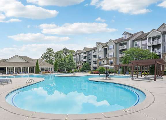 A large outdoor swimming pool surrounded by apartment buildings.