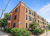 Thumbnail 26 of 67 - a large brick building with a fence in front of it