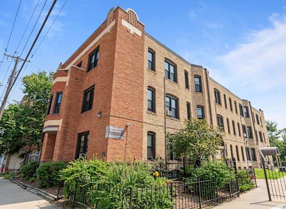 a large brick building with a fence in front of it