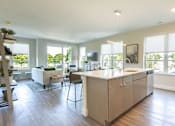 Thumbnail 6 of 28 - A modern kitchen with a large island and a dining area.