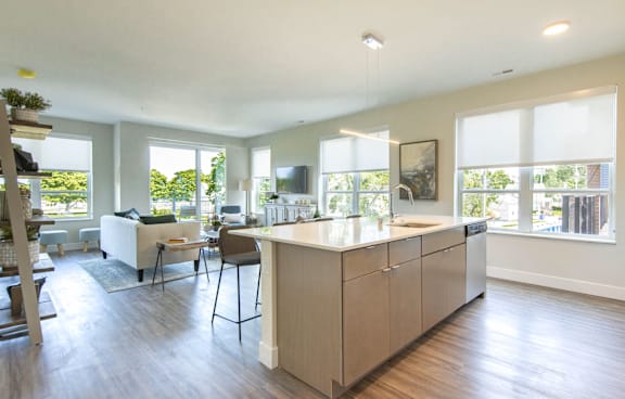 A modern kitchen with a large island and a dining area.