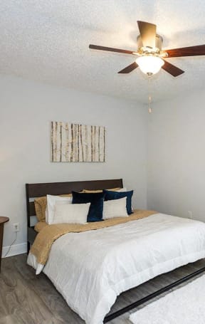 a bedroom with a bed and a ceiling fan