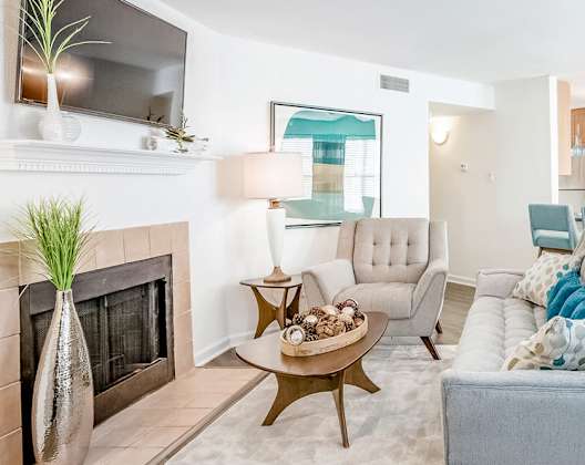 A living room with a grey couch and a fireplace. at Central on the Green Apartment Homes, North Carolina, 27604