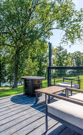 a patio with a grill and a swimming pool with umbrellas at Brightwaters Apartments, Little Rock, Arkansas